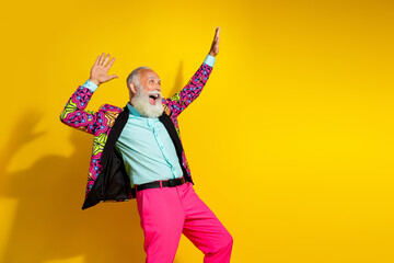 Portrait of isolated on overjoyed aged man colorful designer clothes dance empty space yellow background