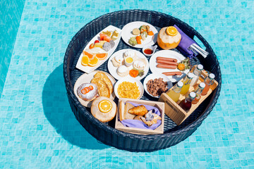 A floating breakfast tray with various dishes and drinks is located in the luxurious pool