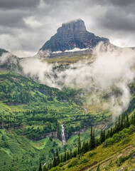 Fog and rain on the Going to the Sun Road.  Approaching Logan Pass with Mount Oberlin and waterfall ahead - Glacier National Park