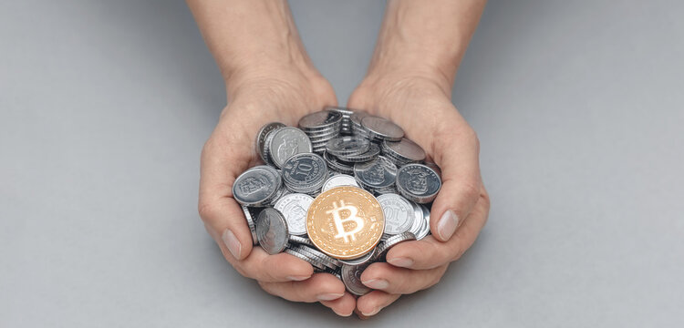Golden bitcoin in palms with coins against gray. Risks, stock market fluctuations and cryptocurrency. - Powered by Adobe
