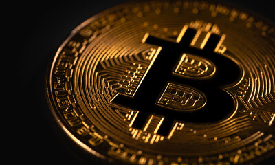 Bitcoin gold coin closeup logo on the dark black background. P2P bitcoin trading. Peer-to-peer payment system. Blockchain technology. Digital cryptocurrency virtual money.