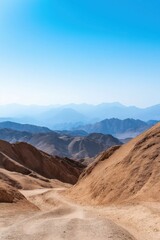 Fototapeta premium A mountain range with a blue sky in the background. The mountains are covered in snow and the sky is clear