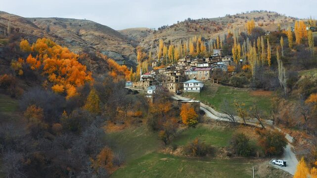 Impressive view of a village in Hizan district of Bitlis, taken with a drone in autumn. It reveals natural beauty with stone houses, golden poplars and mountainous terrain.