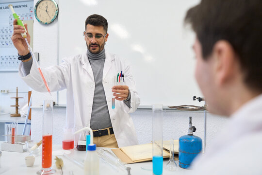 Chemistry teacher performing experiment for students institute - Powered by Adobe