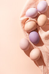 Easter background with colorful pastel eggs on linen napkin. Trendy Easter card in minimalistic style with copy space.