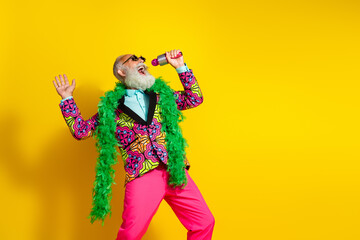 Portrait of crazy extravagant man classy clothes sing microphone empty space isolated on yellow color background