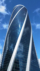 Futuristic Glass Skyscraper: A towering, sleek skyscraper made entirely of reflective glass, featuring curving, organic lines that twist upward, capturing the reflection of the surrounding skyline and