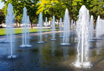 Naklejka premium Water-Responsive Art Installation: A public installation made of perforated metal pipes and delicate water streams that shoot out in rhythmic patterns, which change with every individual's proximity o