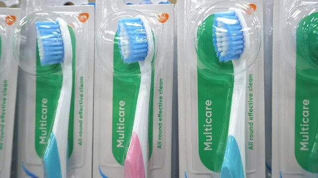 New in the package toothbrushes for men and women in blue and pink, standing in a row one after another