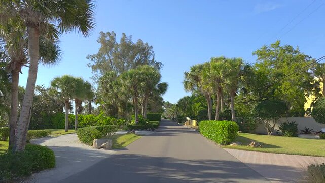Driving on scenic road in sunny Florida. Casey Key coastal residential community picturesque streets.