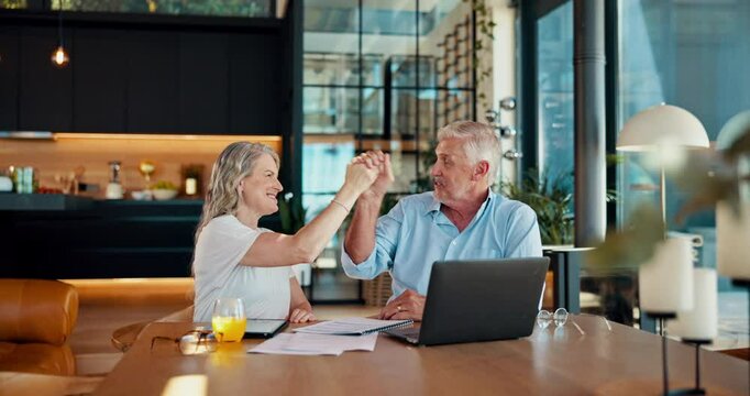 Laptop, high five and mature couple in home booking flight for anniversary weekend trip overseas. Happy, celebration and people with computer cheering for hotel accommodation discount for vacation.