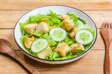 A plate of tofu salad on a wooden table.Diet food.Meat substitute.
