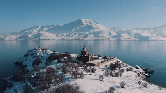 Akdamar Island and the historical Akdamar Church on Lake Van dazzle in drone shots with its fascinating snow-covered view in winter.