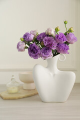 Stylish vase with beautiful flowers and decor on white wooden table at home