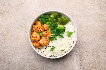 Tasty rice with broccoli, chicken and parsley on grey table, top view