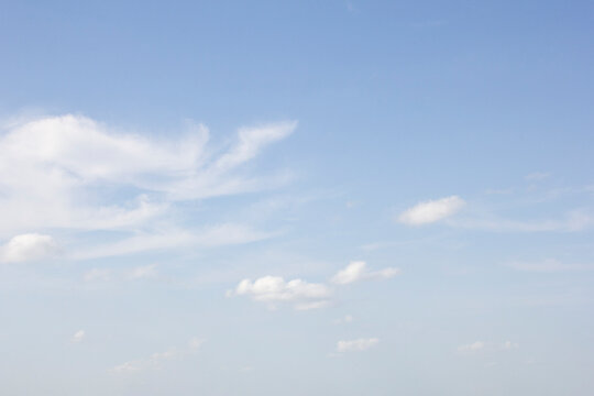A view of a hazy blue sky featuring clouds in a spotted design.