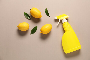 Flat lay composition with spray bottle of cleaning product and lemons on beige background