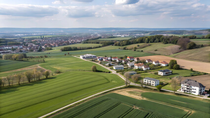 Obraz premium aerial view of a rural landscape with vibrant green fields and a small village