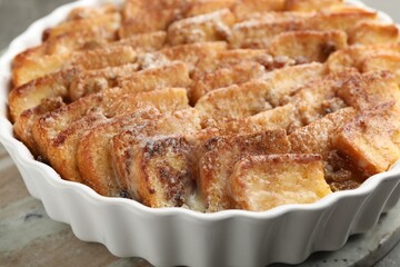 Delicious bread pudding with raisins and cinnamon on grey table, closeup