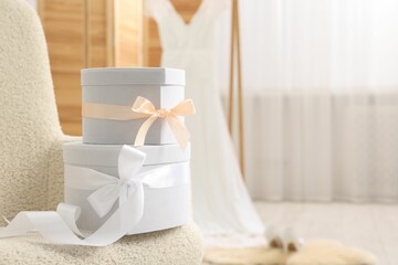 Gift boxes for wedding day in armchair indoors, space for text