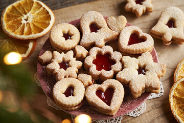 Traditonal Linzer Christmas cookies on a red plate with fir tree branches