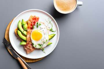 Breakfast sandwich  with fried egg, bacon and avocado