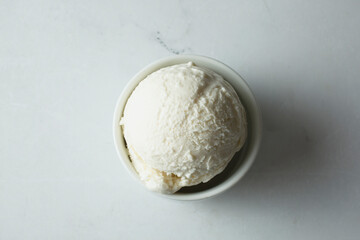 A top down view of a scoop of vanilla ice cream in a cup.