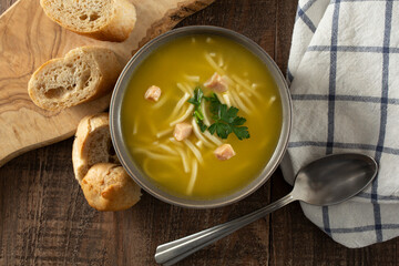 A top down view of a bowl of chicken noodle soup.