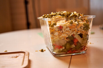 Olivier salad on the table in a glass bowl close-up