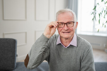 Portrait of confident stylish European middle aged senior man at home. Older mature 70s man smiling. Happy attractive senior grandfather looking camera close up face headshot portrait. Happy people