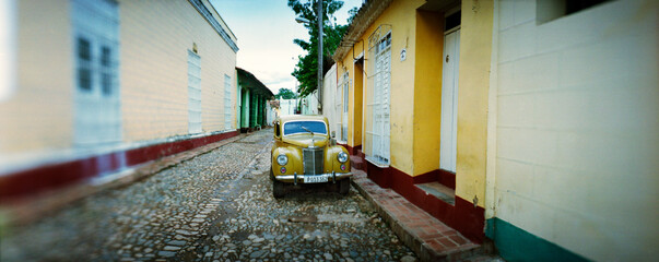 Panoramic image of a vintage car parked on the cobblestone street, Trinidad, Sancti Spiritus, Cuba.