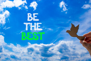 Motivational be the best symbol. Concept words Be the best on beautiful blue sky. Beautiful blue sky and clouds background. Businessman hand. Business motivational be the best concept. Copy space.