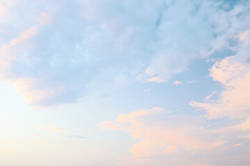 Obraz premium A tranquil evening sky filled with soft pastel colors showcases fluffy clouds, creating a serene atmosphere and inviting relaxation and reflection.