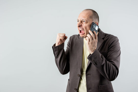 Bald caucasian businessman angry, frustrated and furious with his phone, angry with customer service. Isolated.
 - Powered by Adobe