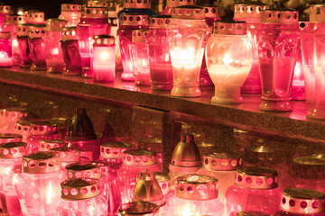Close-Up of Illuminated Red Memorial Candles with Metallic Covers