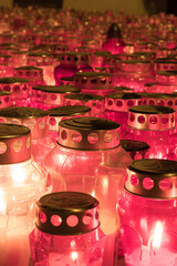 Close-Up of Illuminated Red Memorial Candles with Metallic Covers