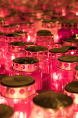 Close-Up of Illuminated Red Memorial Candles with Metallic Covers