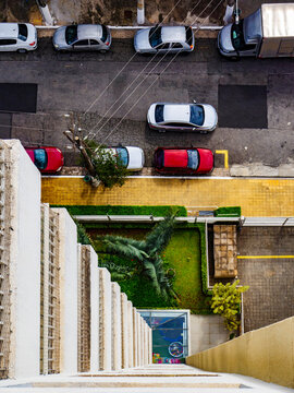 Vista superior de pr&eacute;dio residencial com carros estacionados na rua