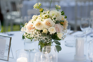 Elegant floral centerpiece adorning a beautifully arranged wedding reception table under soft evening light