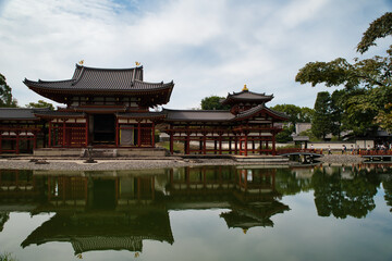 Fototapeta premium View with its reflection in the water of the Byōdō-in, and its garden, is a Buddhist temple located in the city of Uji, Kyoto, Japan. The image appears on the 10 yen coin. World Heritage Site. 