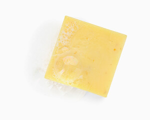 Yellow soap with foam on white background, top view