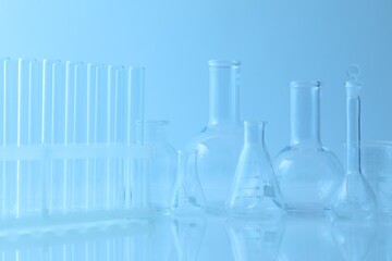 Different laboratory glassware on light blue background