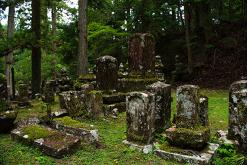 Ancient cemetery at sunset inside a forest, on Mount Koya, Okuno-in or Okunoin cemetery is a sacred area cemetery. In Wakayama prefecture, south of Osaka in Japan.