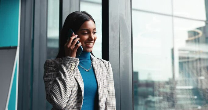 Happy, business woman and window with phone call for corporate discussion, conversation or chat at office. Female person, financial advisor or investor with smile or reflection on mobile smartphone