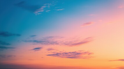 Obraz premium A stunning sunset sky with vibrant hues of orange and pink, showcasing softly scattered clouds creating a peaceful atmosphere.