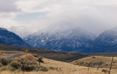 Fototapeta premium Scenic view from a road leading into cloud covered mountains during the winter in Wyoming.