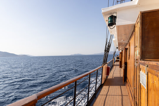 Cruise ship deck on a sailing holiday in Greece with late afternoon light on the wood deck.