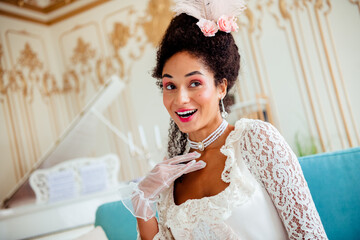 Elegant woman in vintage attire posing in a luxurious aristocratic interior with ornate details