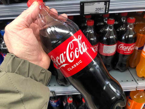 A customer holds a bottle of Coca Cola water in a supermarket.