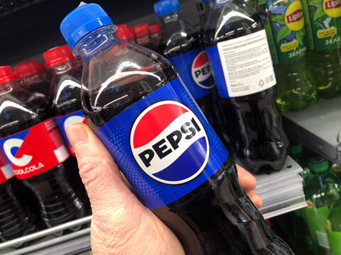 A customer holds a bottle of Pepsi water in a supermarket.